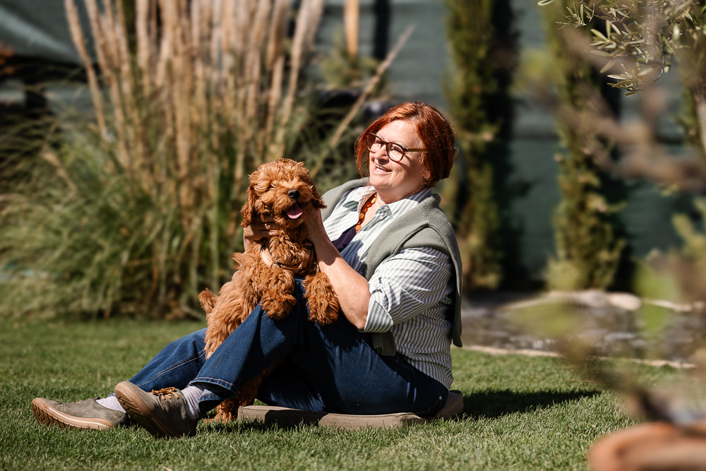 Maria Neuberger und Enie auf einer Wiese im Therapiegarten am Caprahof